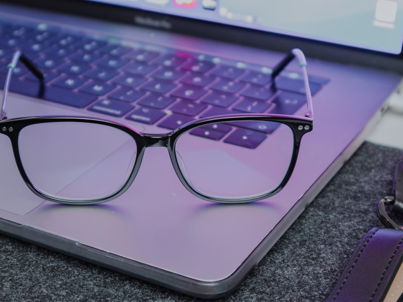 Blauwlichtbril naast een laptop op een bureau