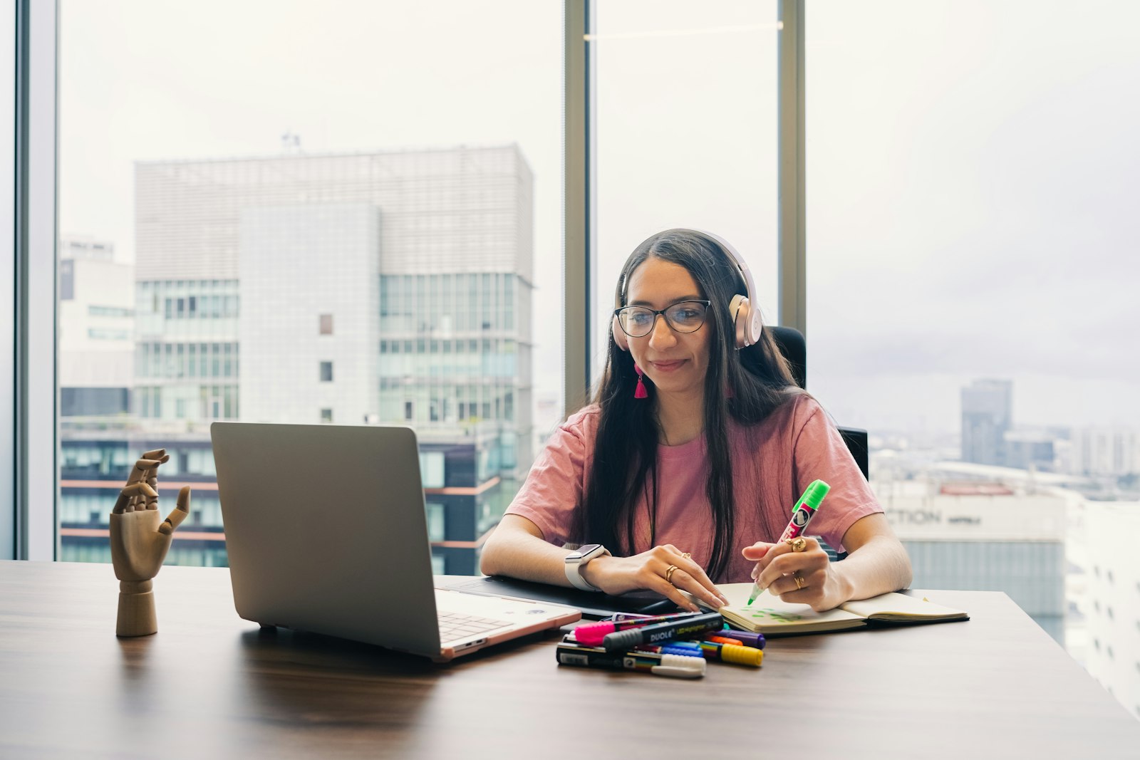 Persoon met noise-canceling koptelefoon werkt rustig achter een bureau
