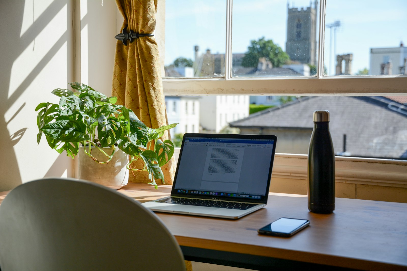 Overzichtelijke, opgeruimde thuiswerkplek met bureau, stoel en accessoires